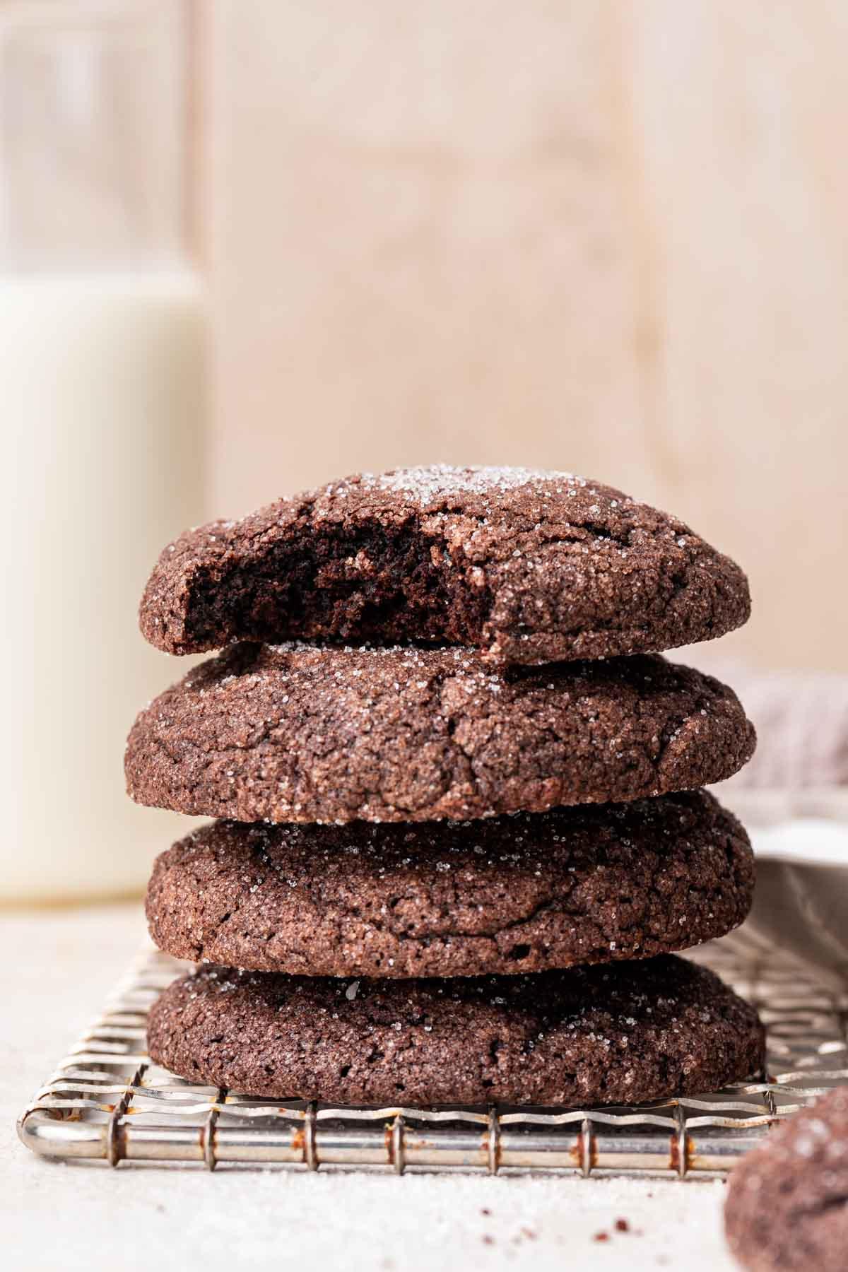 Stack of chocolate sugar cookies with bite missing from top one.