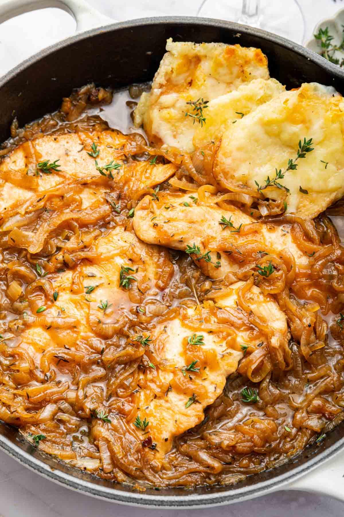Ricetta del Pollo alla Cipolla Francese 2 Macro immagine di Pollo alla Francese con cipolle caramellate in padella con pane tostato a lato.