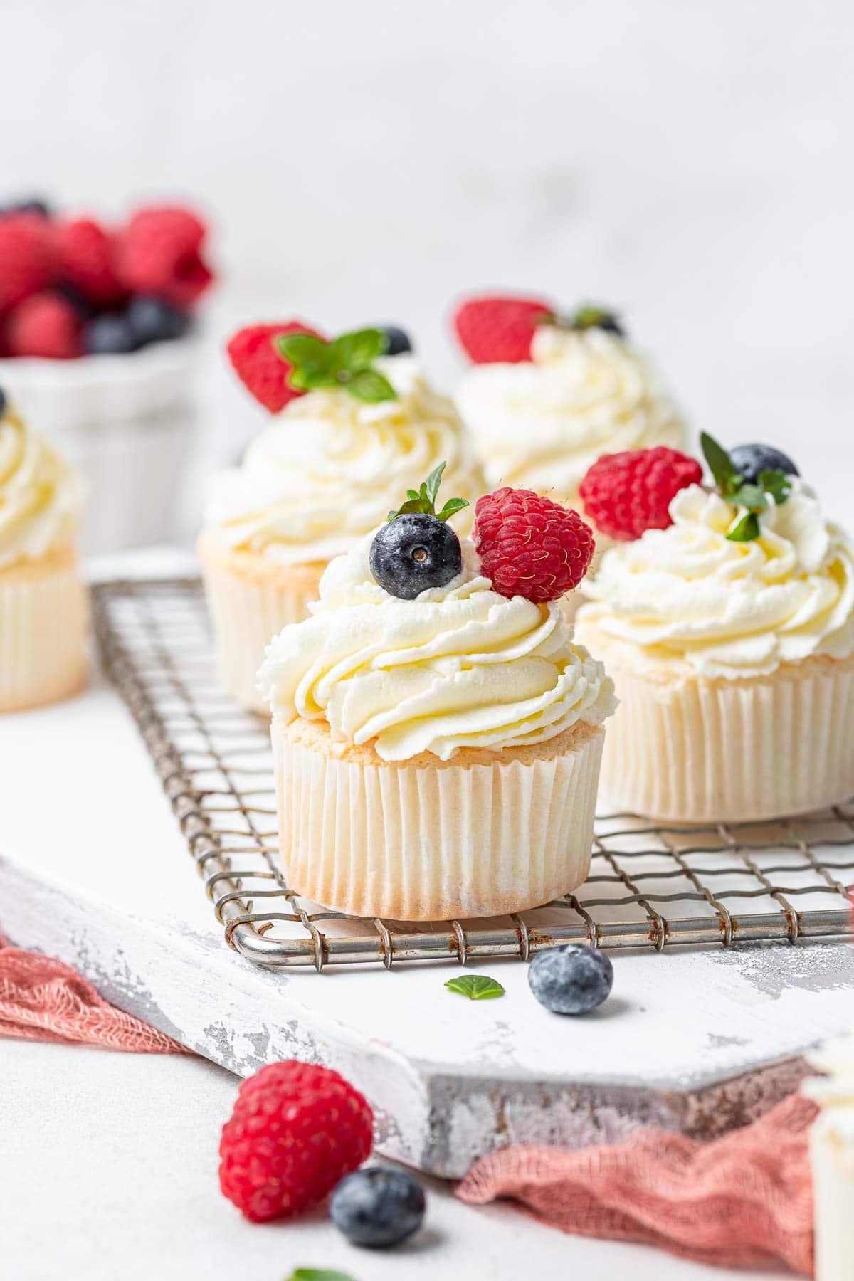 Tortini Angel Food 2 Quattro muffin Angel Food bianchi su griglia con frutti di bosco freschi.