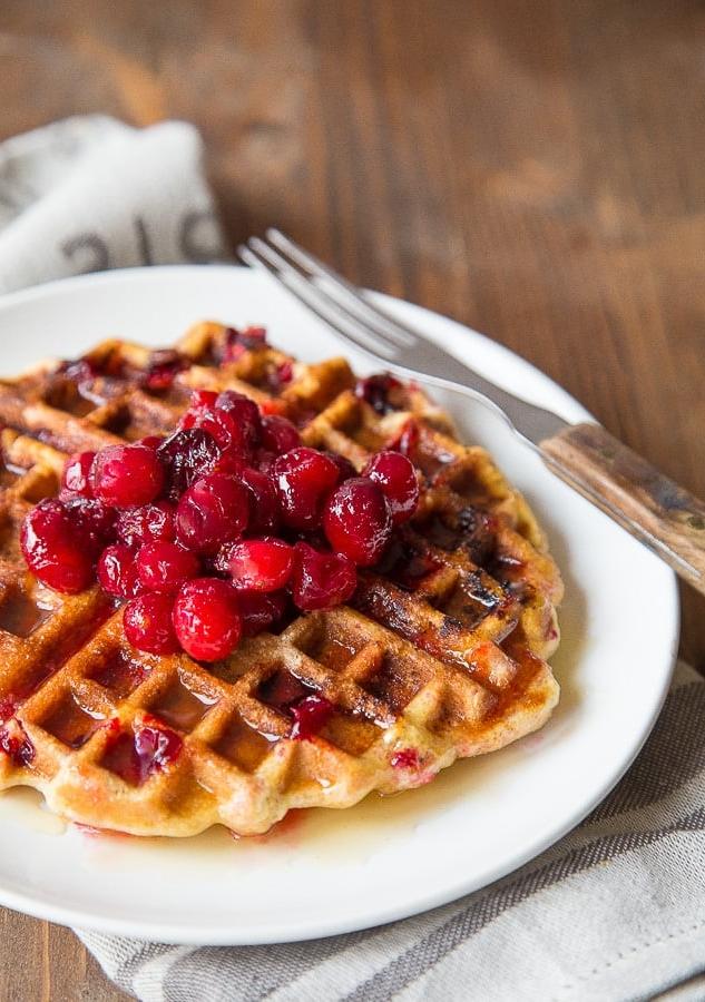 Usa quella salsa di mirtilli rossi avanzata in questi waffle di farina di mais. Ricetta bonus per lo sciroppo di sidro!