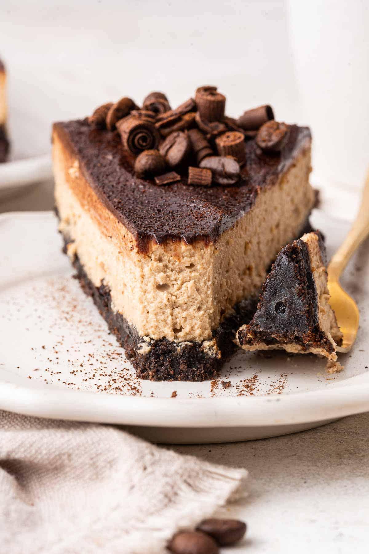 Cheesecake al caffè 2 Fetta di cheesecake al caffè decorata con riccioli di cioccolato, vista ravvicinata.