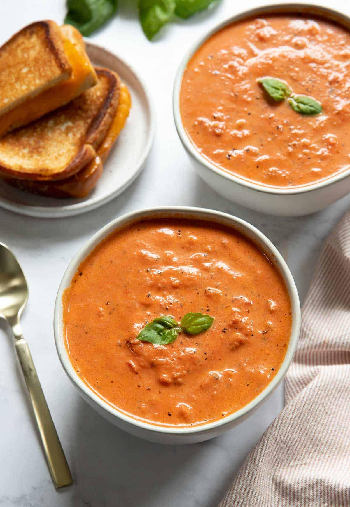 Zuppa di pomodoro Instant Pot 2 Due ciotole di zuppa di pomodoro con formaggio grigliato al lato.