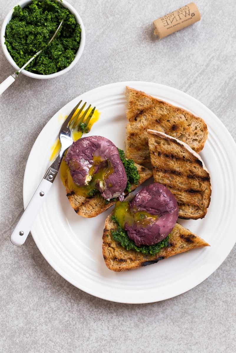 Uova in camicia al vino rosso su toast con pesto di cavolo nero