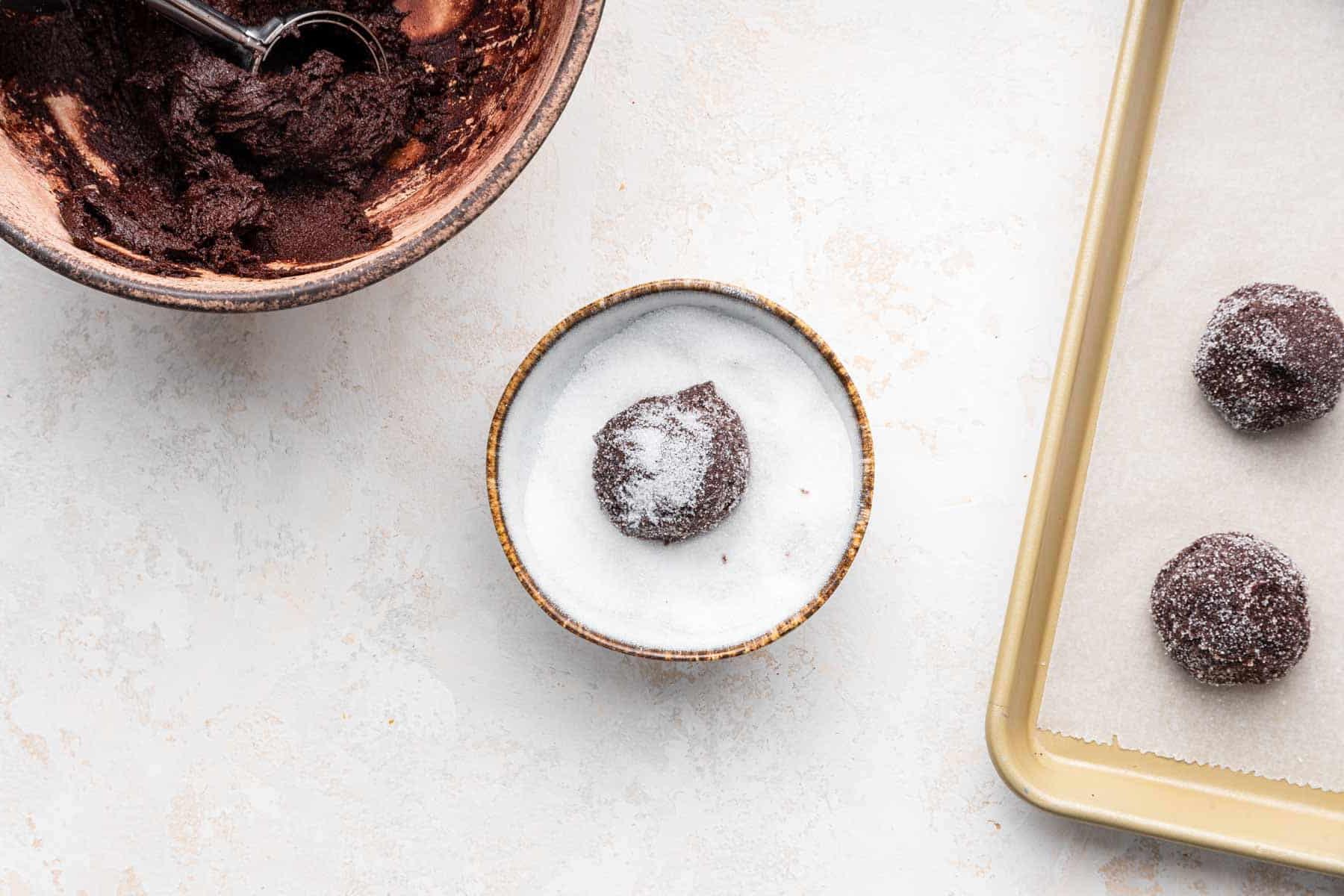 Round brown ball in bowl of white sugar.