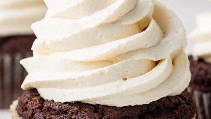 Close up photo of white swirled marshmallow frosting on a chocolate cupcake.