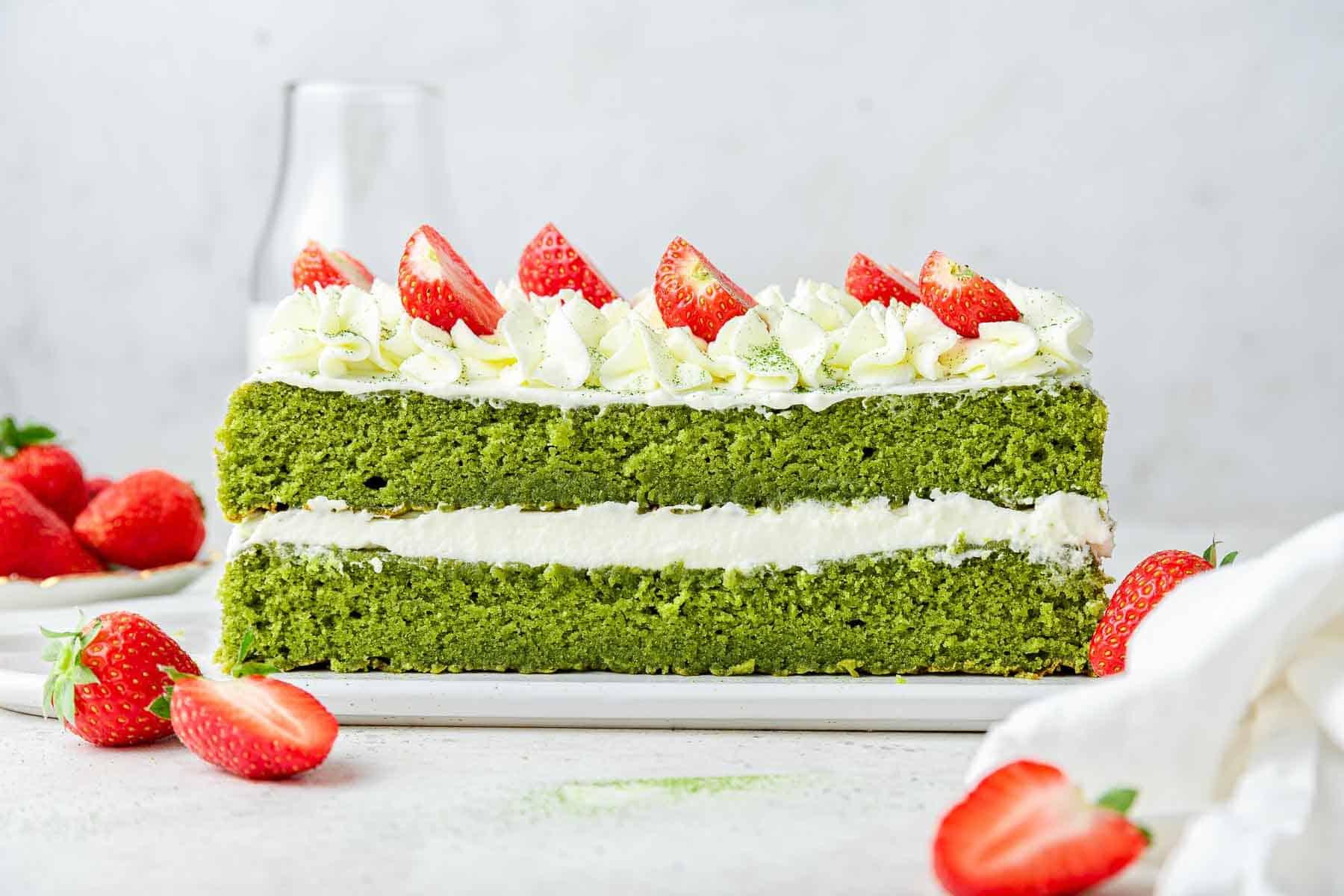 Torta al Matcha 13 Scatto laterale di una torta a strati verde ricavata da una teglia quadrata.