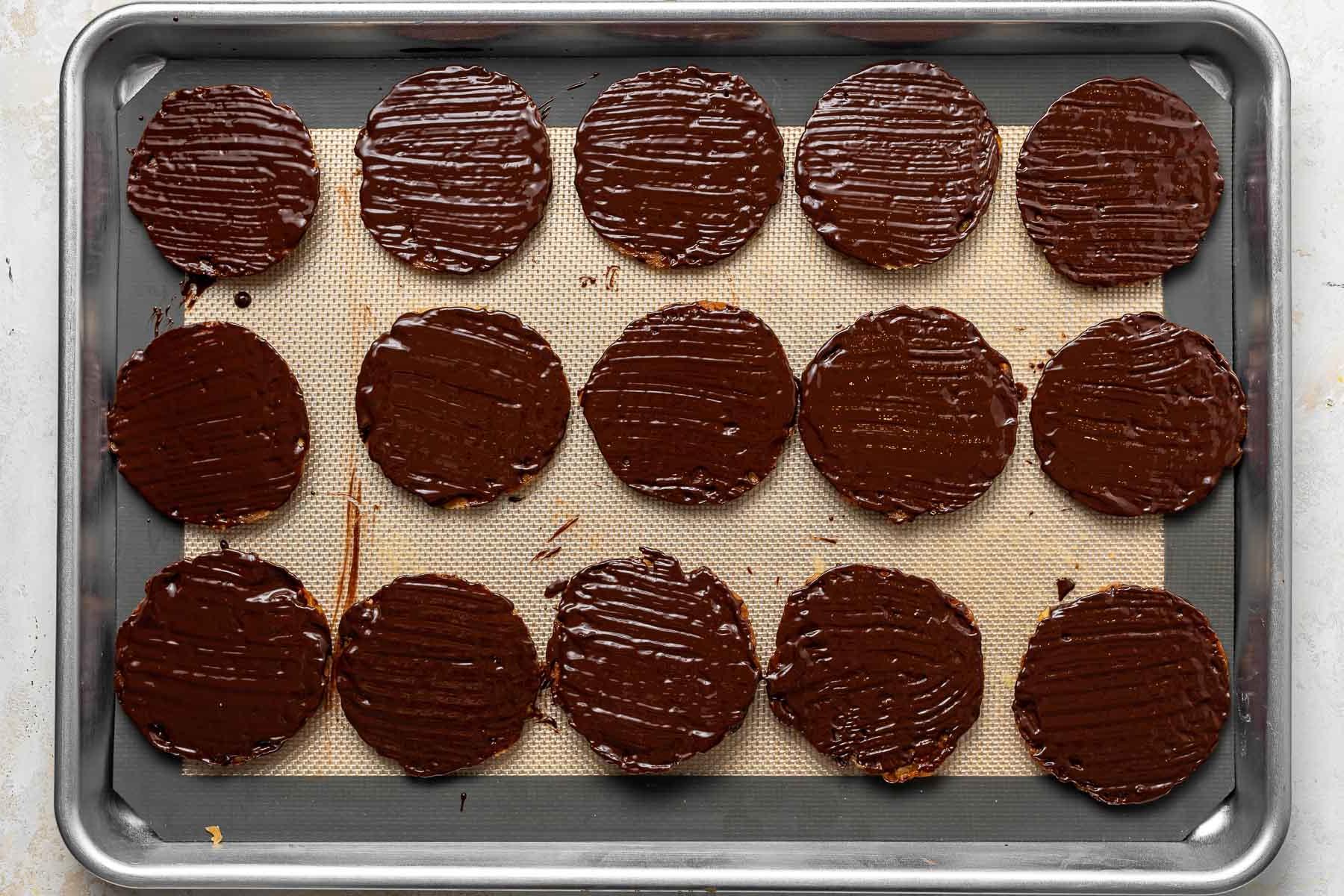 Biscotti intinti nel cioccolato su una teglia.