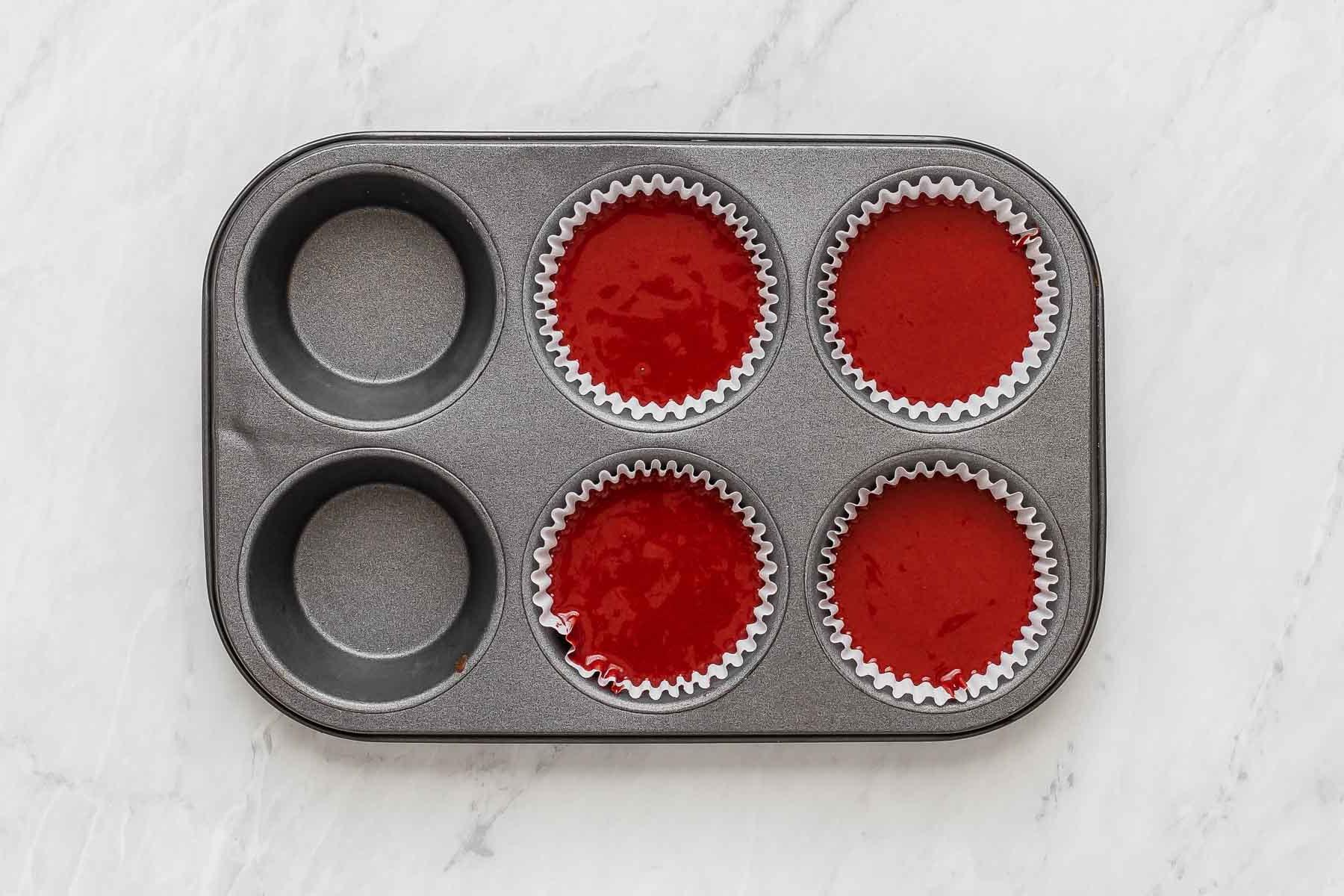 Quattro cupcake Red Velvet in una teglia per muffin.