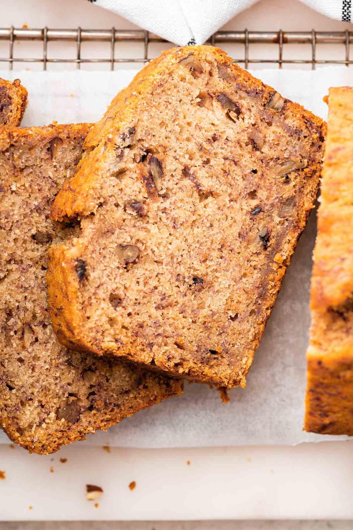 Pane alle banane senza uova 3 Macro scatti di fette di banana bread senza uova con noci pecan.