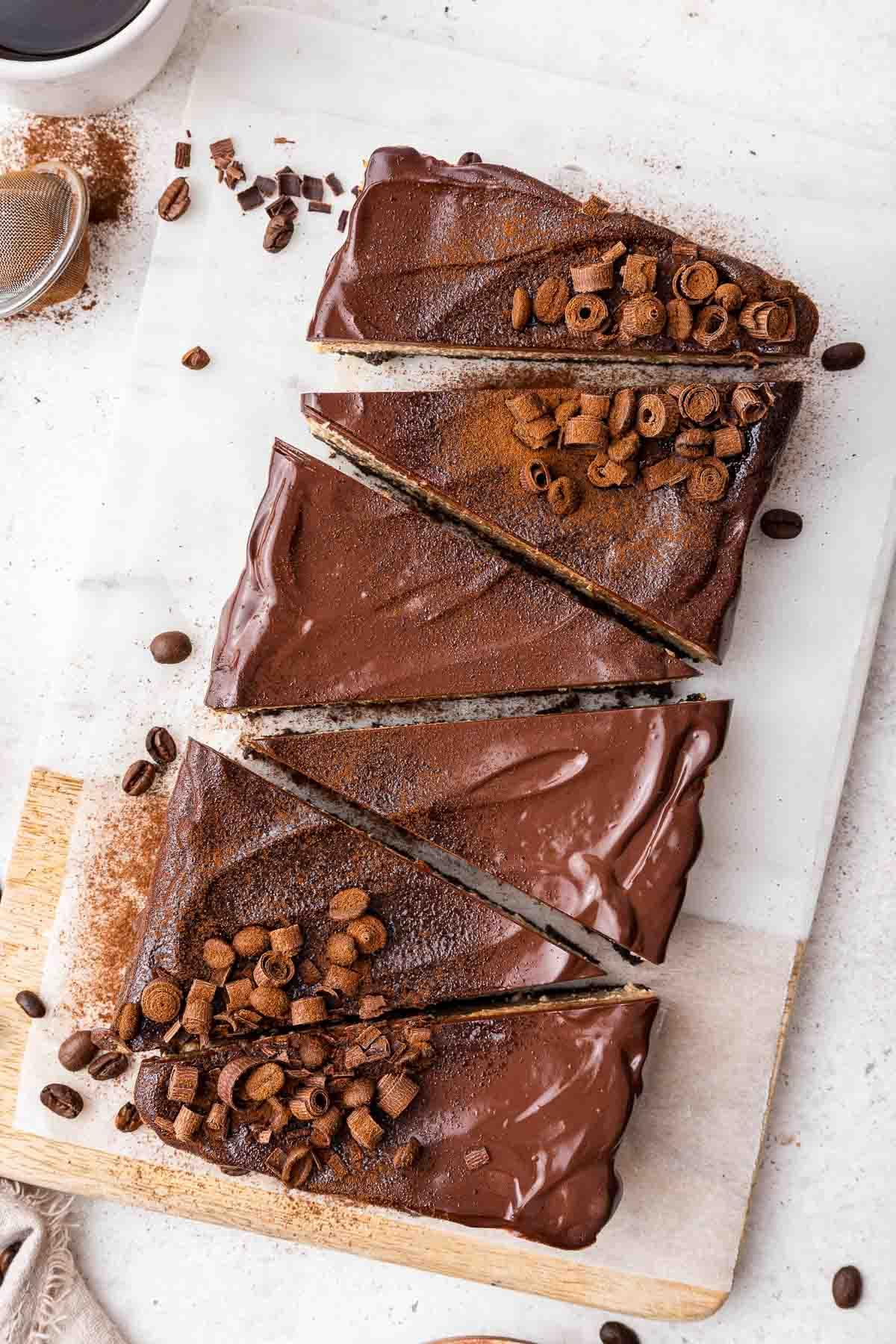Cheesecake al caffè 3 Sei fette di cheesecake al cioccolato decorate con ganache e riccioli di cioccolato.