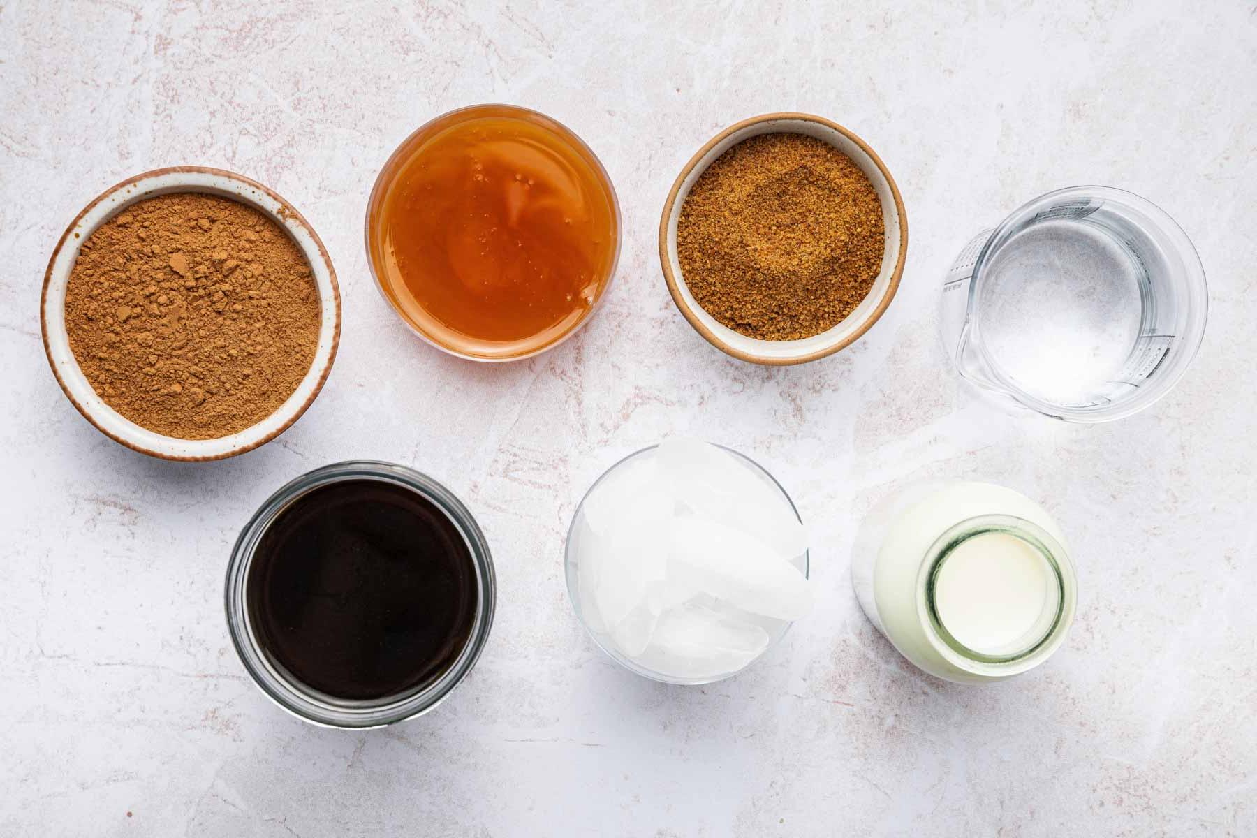 Ricetta Mocaccino Ghiacciato 3 Piccole ciotole di zucchero, latte e ghiaccio su un bancone della cucina.