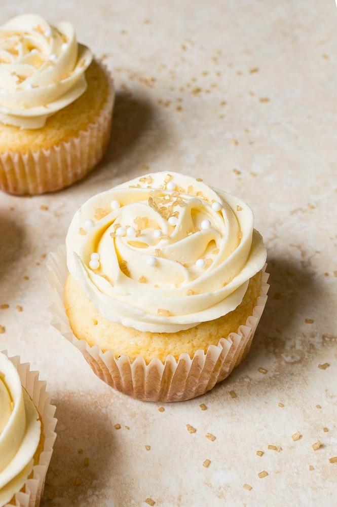 Cupcake nuziali con mandorle e rose di crema al burro. Cupcake in piccole porzioni per anniversario di matrimonio