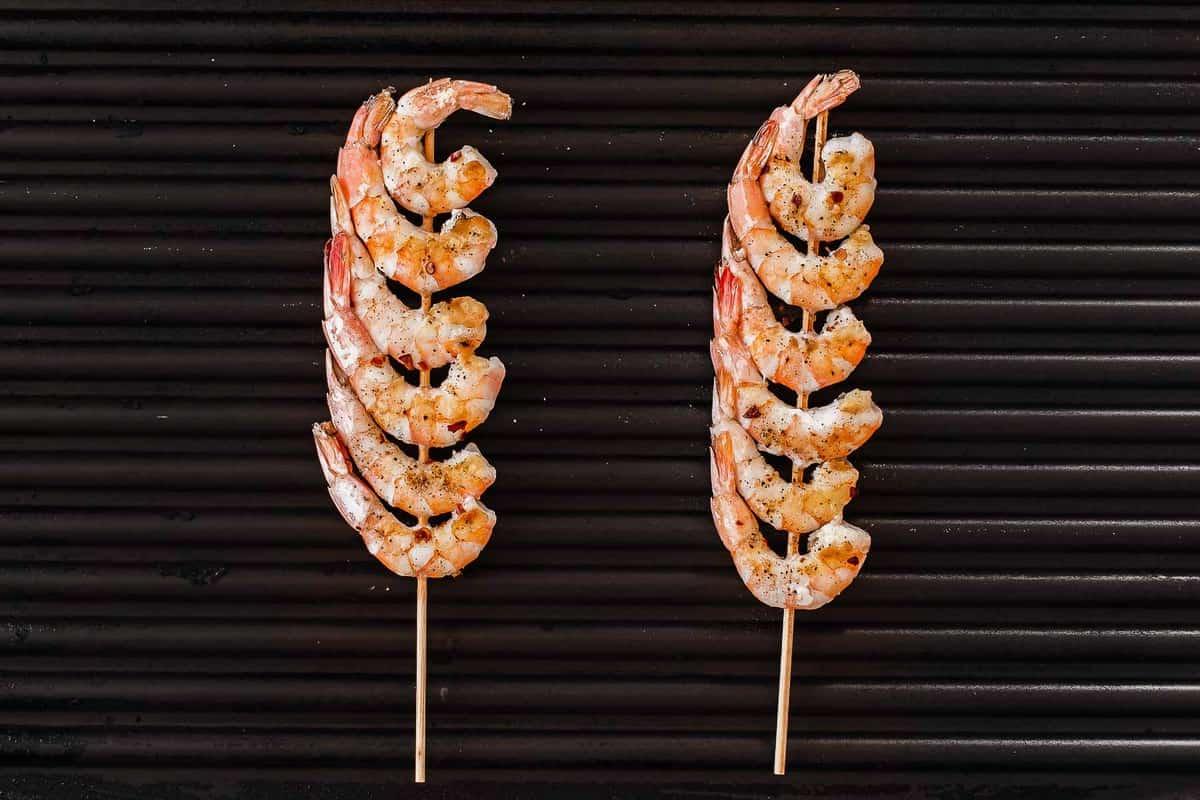 Gamberi su spiedini su una padella griglia.