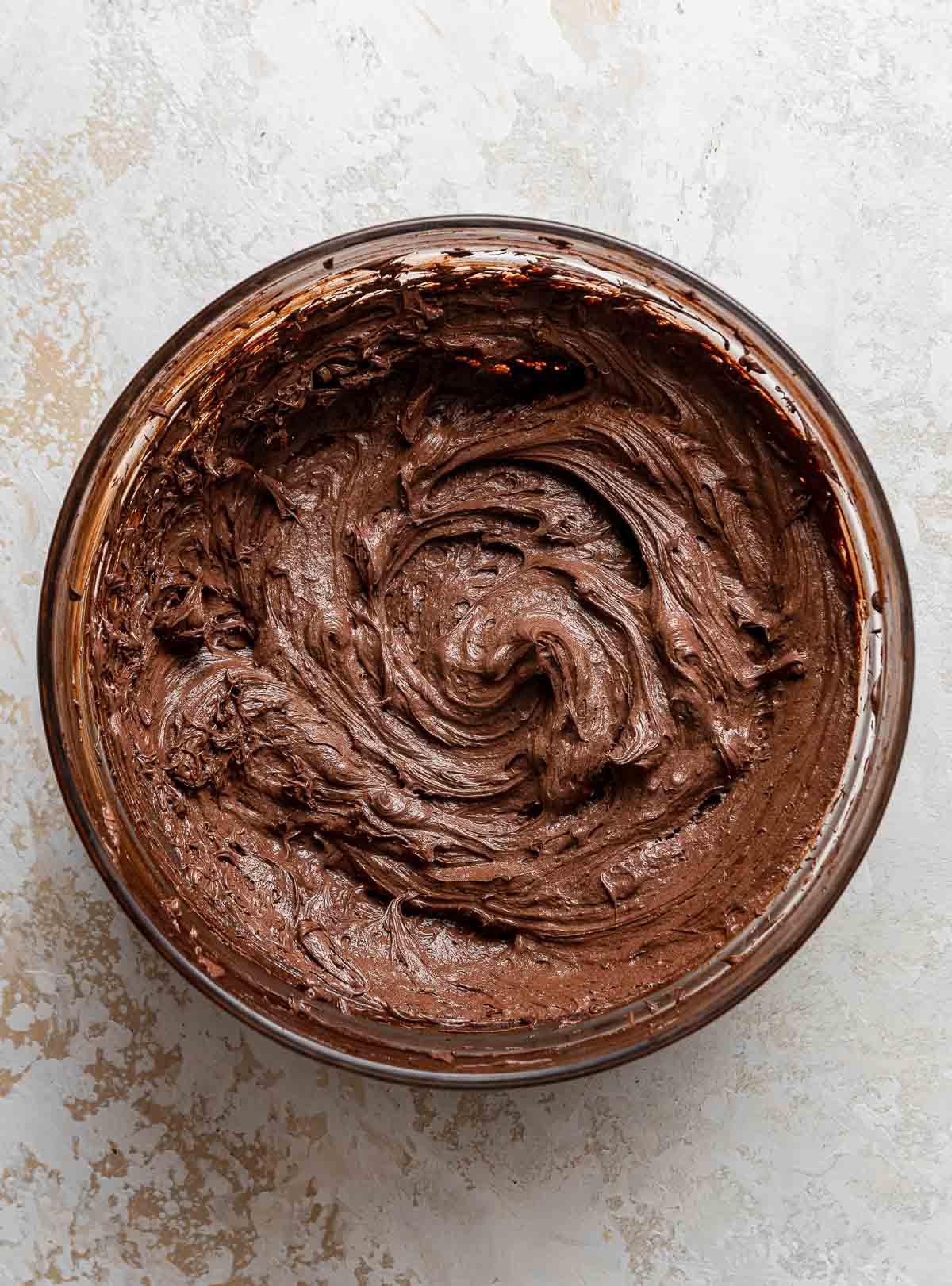 Ciotola rotonda di glassa al cioccolato montata.