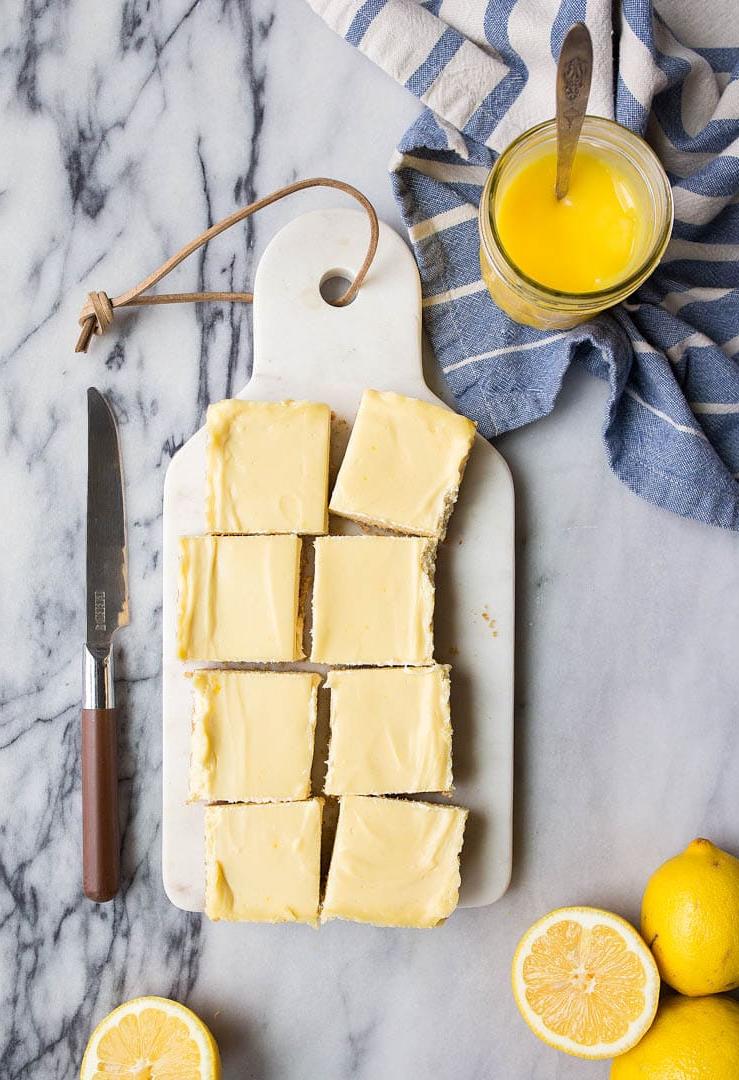 Barrette di Cheesecake al Limone con Curd Fatto in Casa. Le cheesecake bar al limone sono un dessert estivo divertente e facile da preparare.
