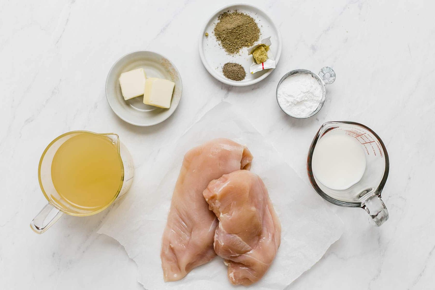 Pollo Cremoso in Pentola a Cottura Lenta 4 Ingredienti per la ricetta di pollo in slow cooker su tavolo bianco.