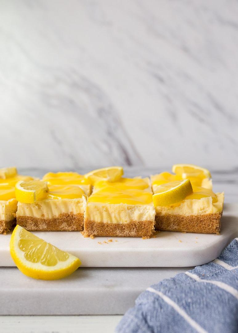 Barrette di Cheesecake al Limone con Curd Fatto in Casa. Le cheesecake bar al limone sono un dessert estivo divertente e facile da preparare.