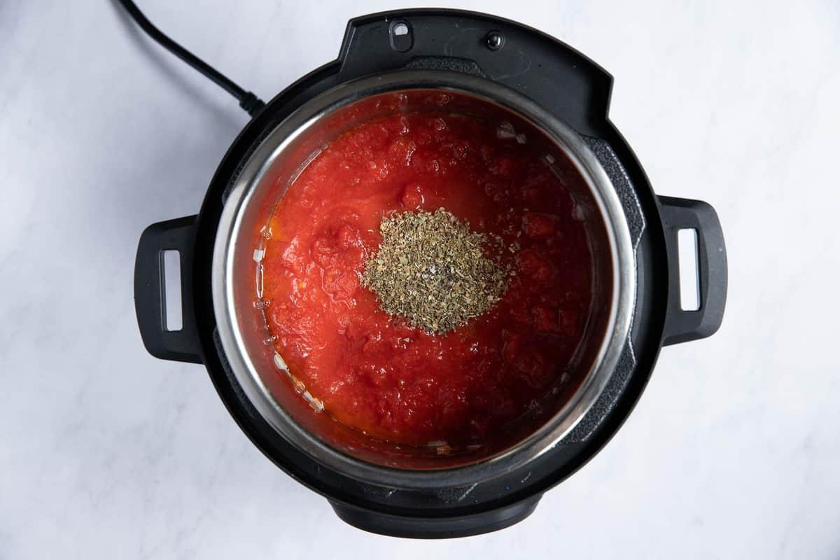 Instant Pot con salsa di pomodoro ed erbe al centro.
