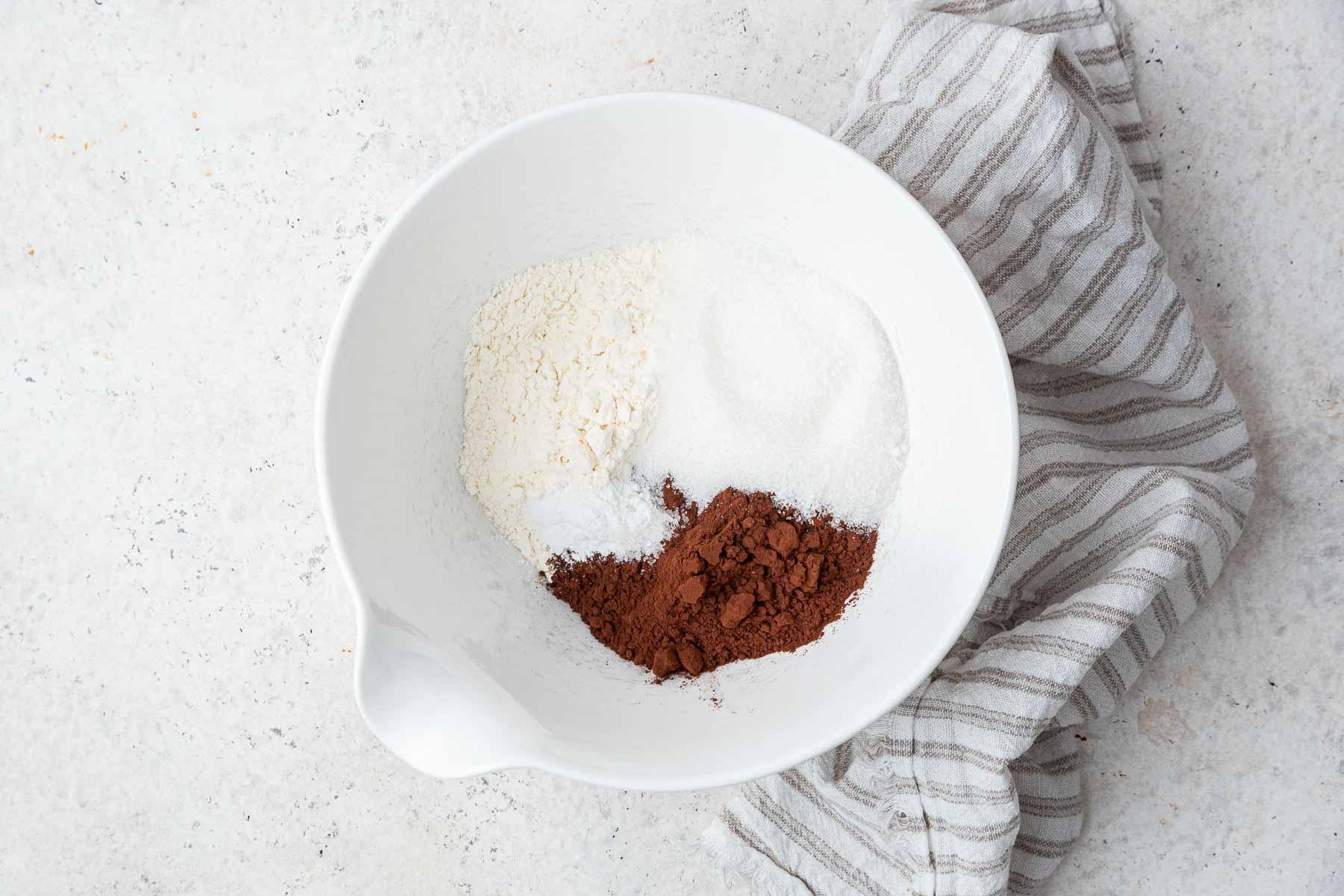 Ricetta Torta al Cioccolato in Tazza 5 Ciotola bianca con farina, cacao in polvere, lievito e sale.