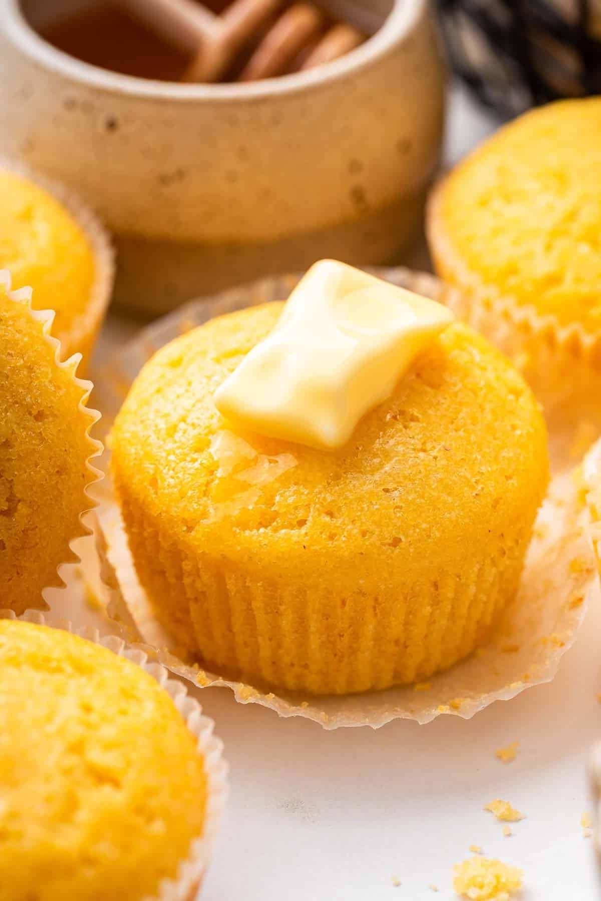 Ricetta Muffin al Mais 5 Dolce giallo con una noce di burro sopra.