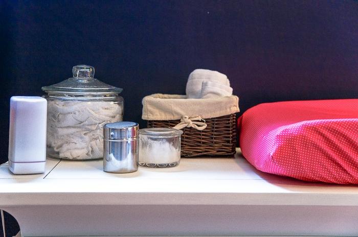 Stanza da bambina in tonalità blu navy e rosa con fasciatoio ben organizzato e accessori per il cambio