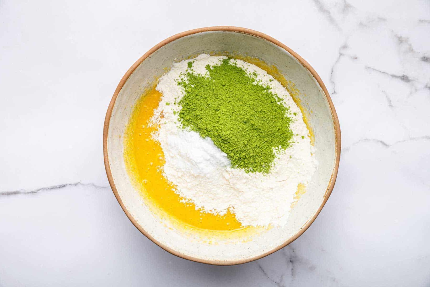 Biscotti al Tè Verde Matcha 6 Impasto giallo con farina e polvere di matcha verde sopra.
