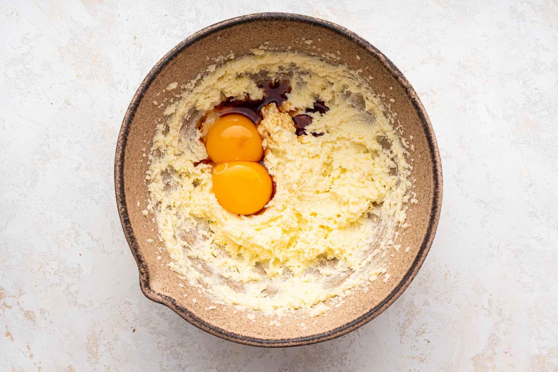 Biscotti Ciambella 6 Egg yolks and vanilla over cookie dough in brown bowl.