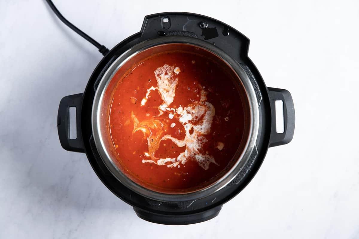 Zuppa di pomodoro con spruzzi di panna fresca mescolati.