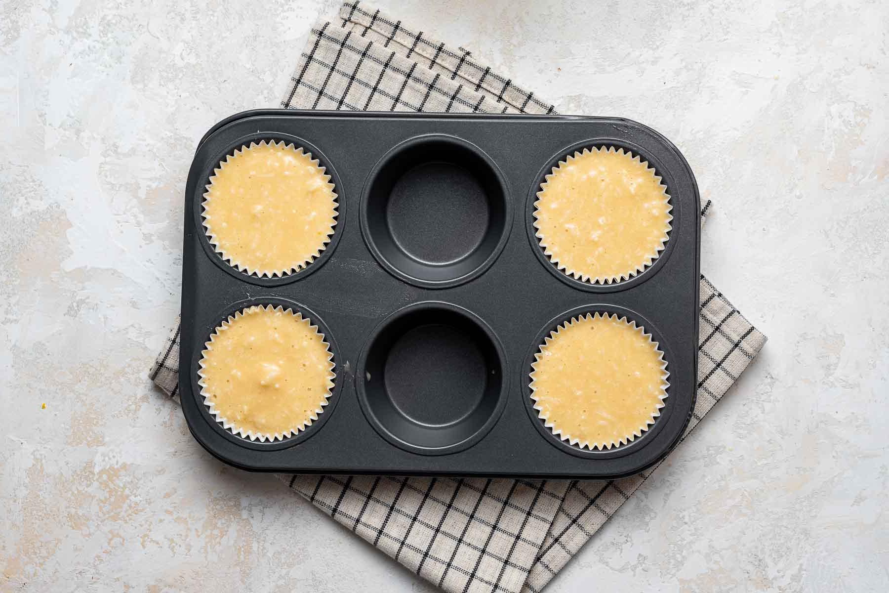 Impasto crudo dei cupcake nella teglia da muffin.