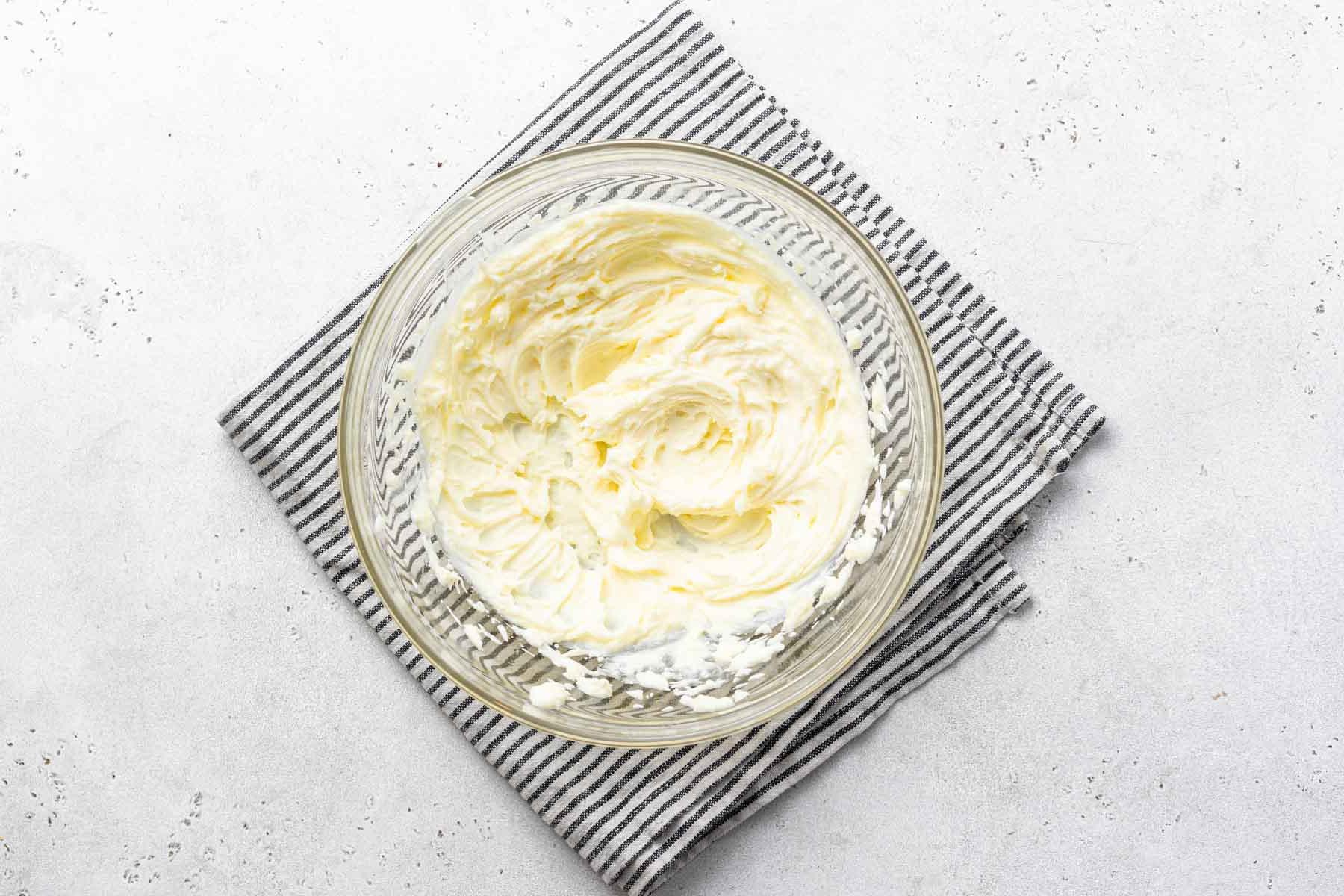 Glassa al formaggio spalmabile e limone in una ciotola trasparente.