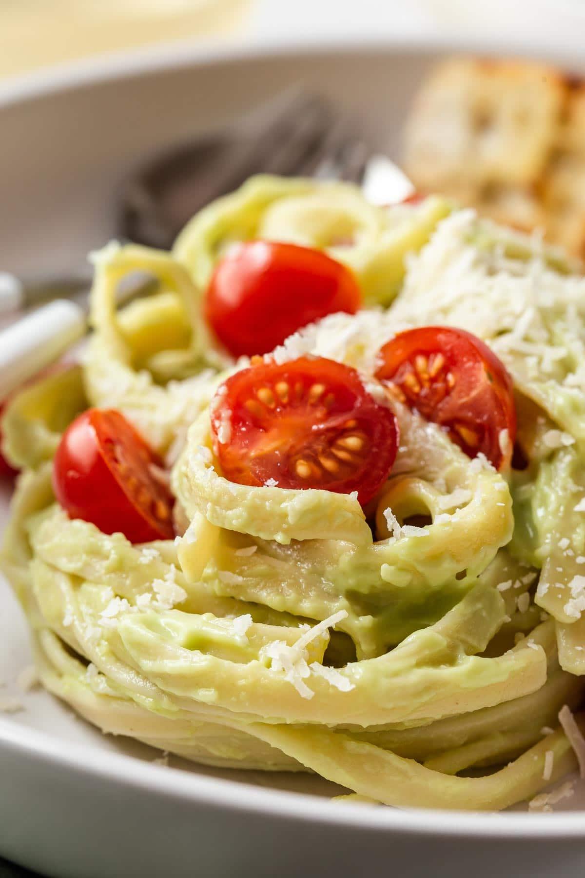 Avocado sauce on noodles with cherry tomatoes.