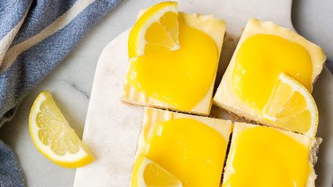 Barrette di Cheesecake al Limone con Curd Fatto in Casa. Le cheesecake bar al limone sono un dessert estivo divertente e facile da preparare.