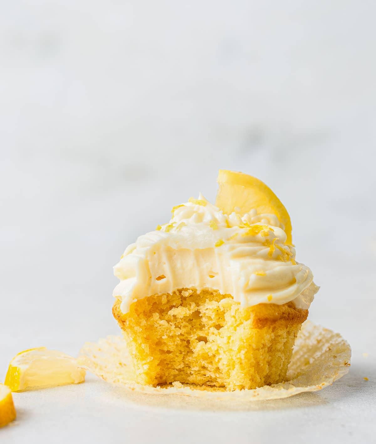 Cupcake singolo giallo con glassa al formaggio spalmabile e fetta di limone.