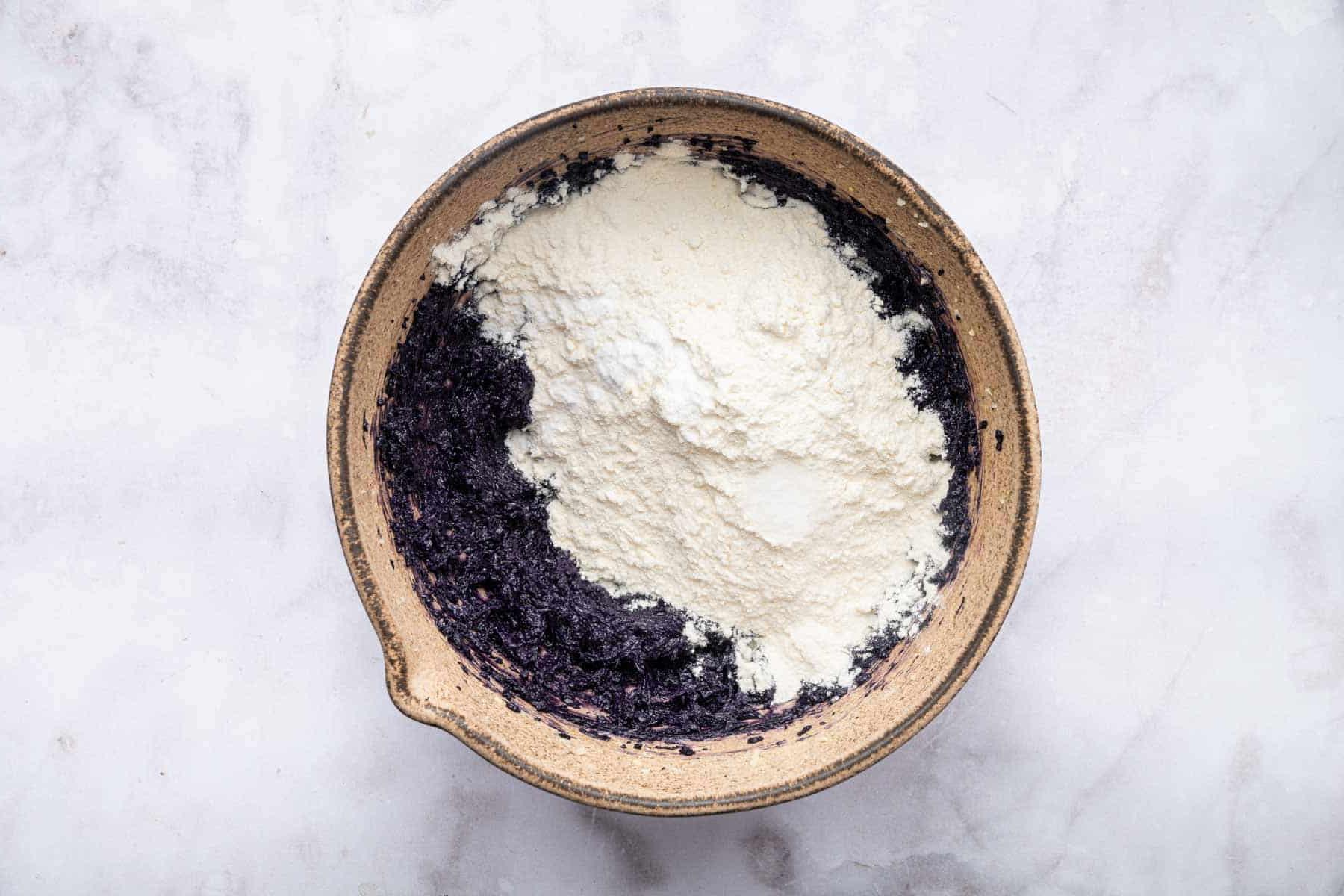 Farina bianca sparsa sull'impasto viola.