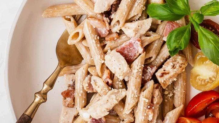Pasta con Pollo e Bacon 7 Immagine dall'alto di pasta cremosa su un piatto con pancetta, pollo e pomodorini freschi