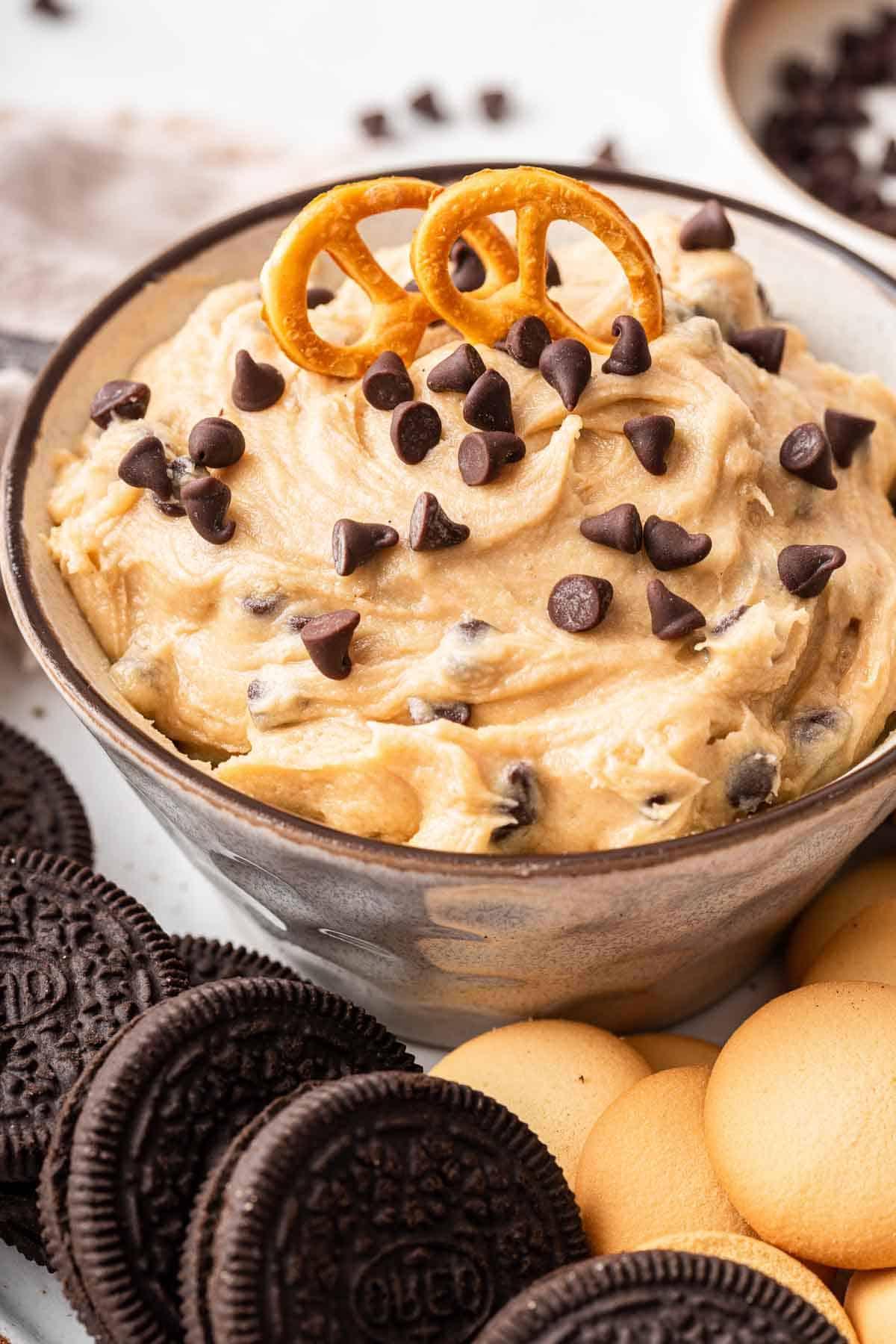 **Crema Impasto Biscotti Monoporzione** 7 Ciotola di dip di impasto per biscotti con un pretzel posato sopra, pronto per essere intinto.