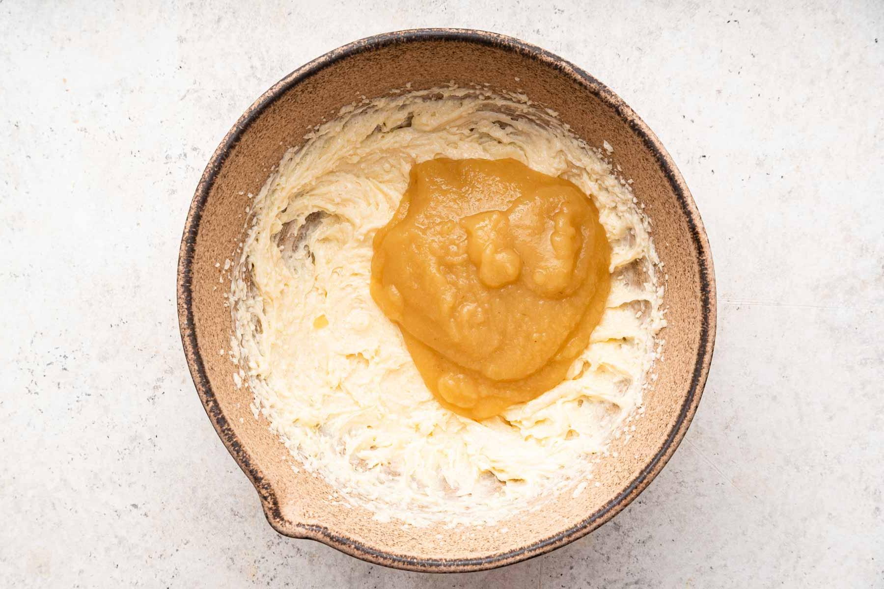 Pane alle banane senza uova 7 Miele e salsa di mele versati su burro e zucchero cremati in una ciotola marrone.