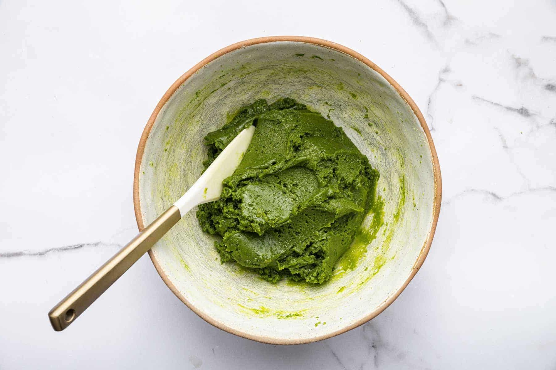 Biscotti al Tè Verde Matcha 7 Impasto verde brillante in una ciotola bianca con una spatola bianca.