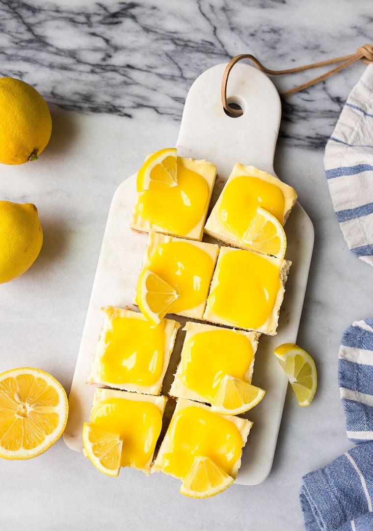 Barrette di Cheesecake al Limone con Curd Fatto in Casa. Le cheesecake bar al limone sono un dessert estivo divertente e facile da preparare.