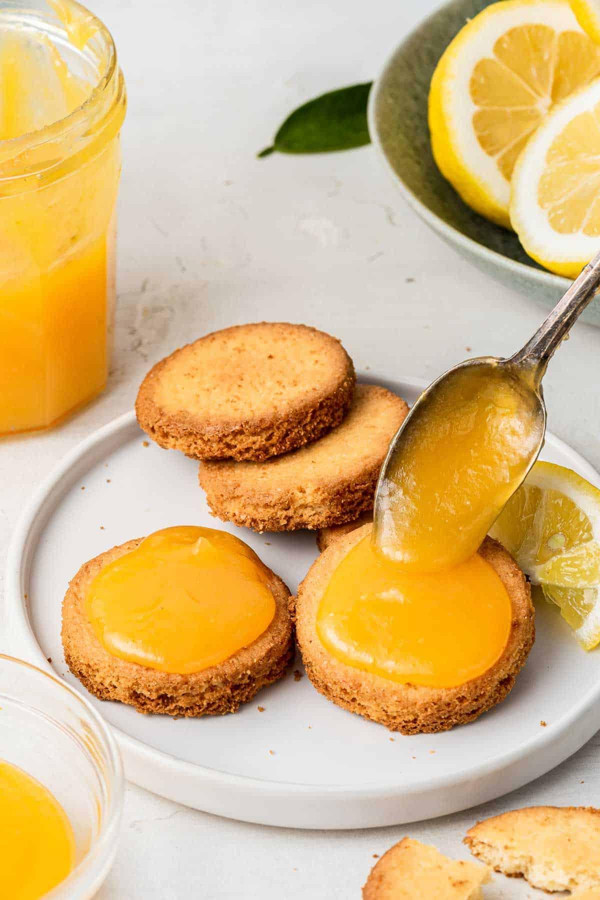 **Lemon Curd al Microonde in Piccola Quantità** 8 Crema al limone al microonde servita su biscotti shortbread con un cucchiaio.