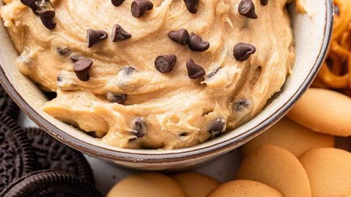 **Crema Impasto Biscotti Monoporzione** 8 Immagine verticale di dip di impasto per biscotti in ciotola bianca circondata da biscotti.