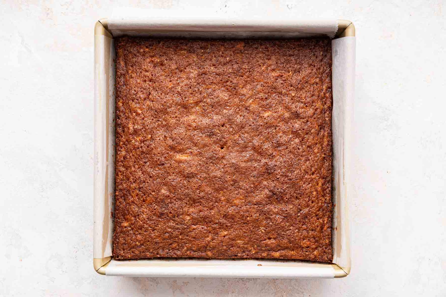 **Tortina di Carote con Glassa al Formaggio Cremoso al Caramello** 8 Teglia quadrata con la torta marrone all'interno, pronta per essere sfornata o raffreddata.