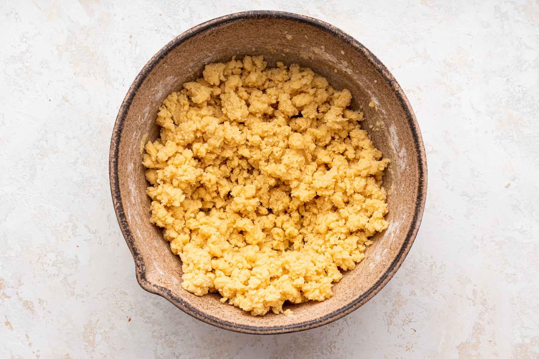Biscotti Ciambella 8 Crumbly yellow cut out sugar cookie dough in brown bowl.