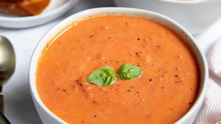 Zuppa di pomodoro Instant Pot 8 Due ciotole di zuppa di pomodoro con formaggio grigliato e basilico fresco.