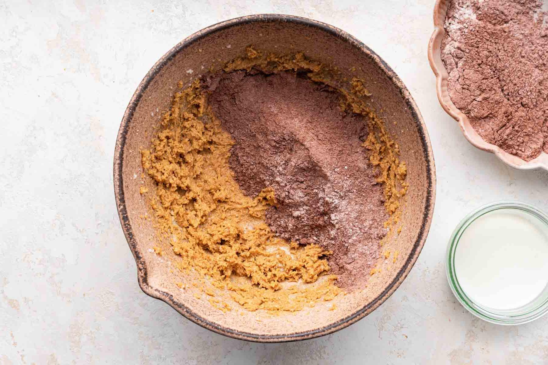 Dry cocoa powder over yellow cookie dough.