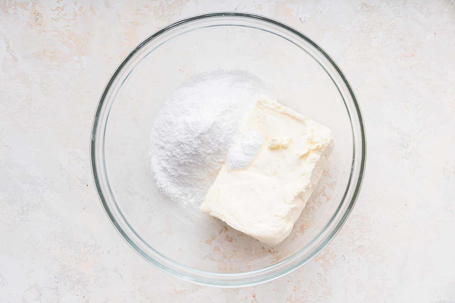 **Tortina di Carote con Glassa al Formaggio Cremoso al Caramello** 10 Ciotola trasparente con formaggio cremoso e zucchero a velo, ingredienti chiave per la glassa.