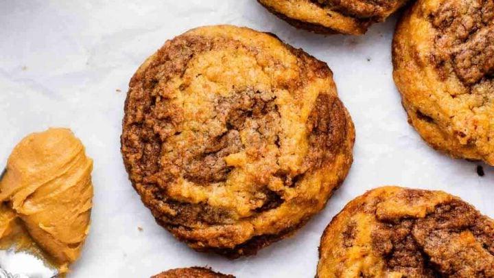 Biscotti al Burro di Arachidi e Nutella 10 Biscotti al burro di arachidi e cioccolato vorticosi su un tavolo bianco.