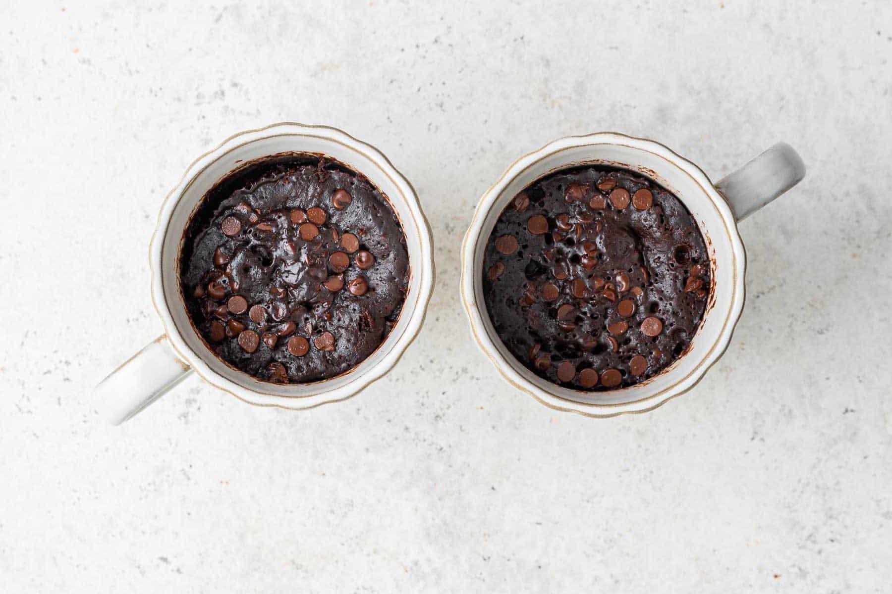 Ricetta Torta al Cioccolato in Tazza 10 Torte al cioccolato in tazza appena uscite dal microonde in 2 tazze.