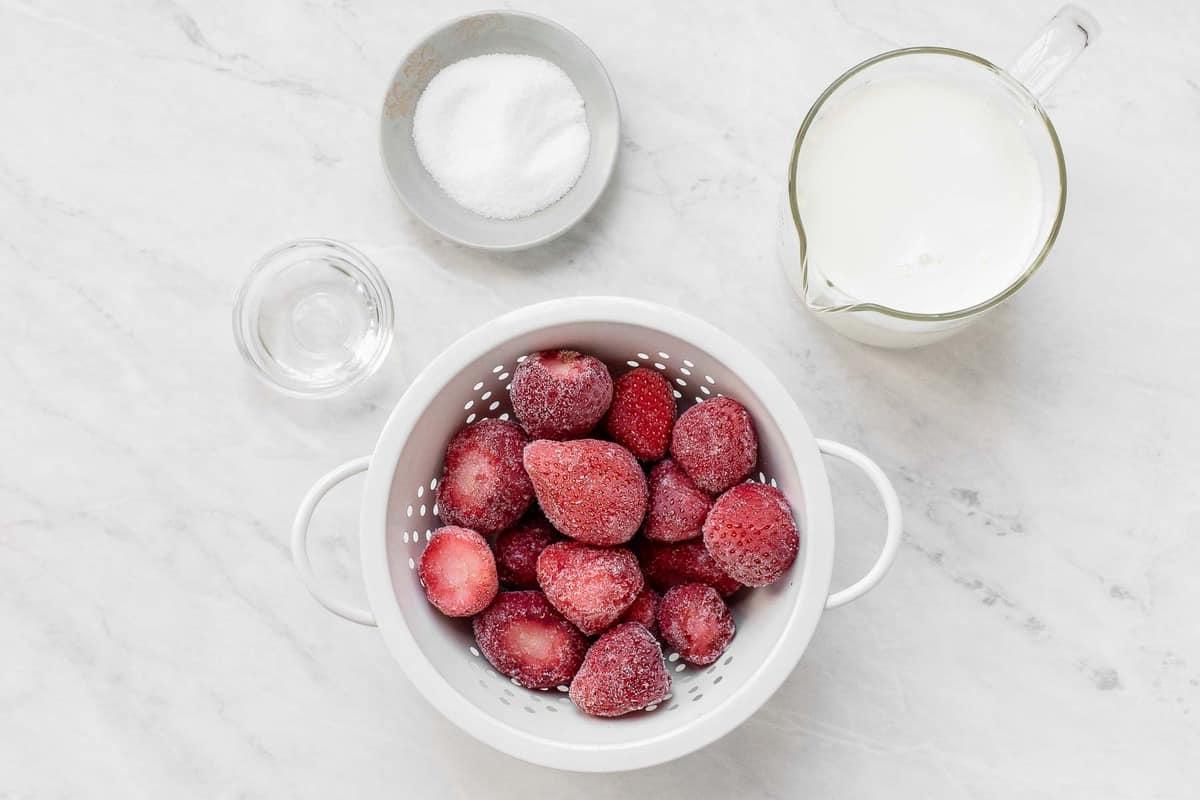 Fragole, latte e zucchero sul tavolo.
