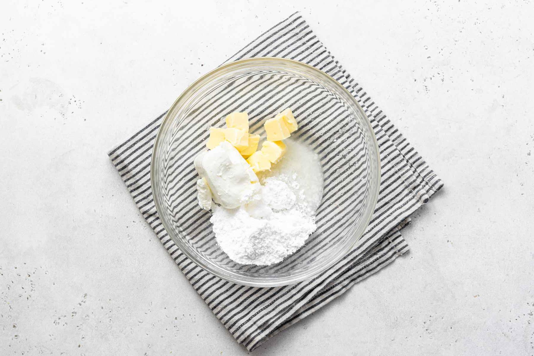 Ingredienti per glassa al formaggio spalmabile e limone nella ciotola.